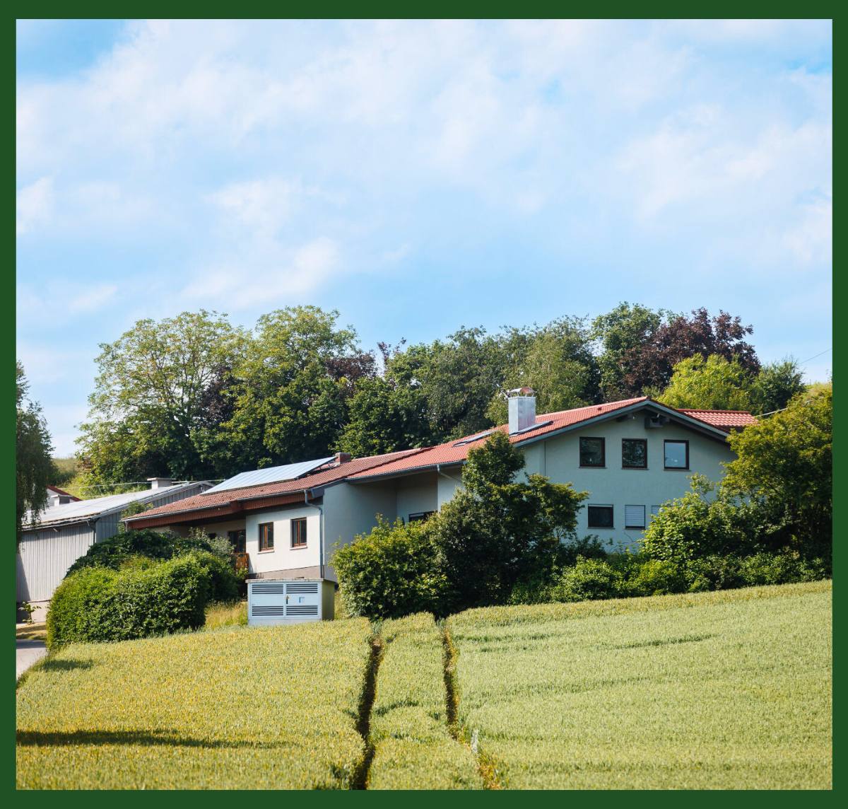 Die Pension und das Gebäude des HBD-Unternehmens, umgeben von grüner Vegetation und Bäumen.