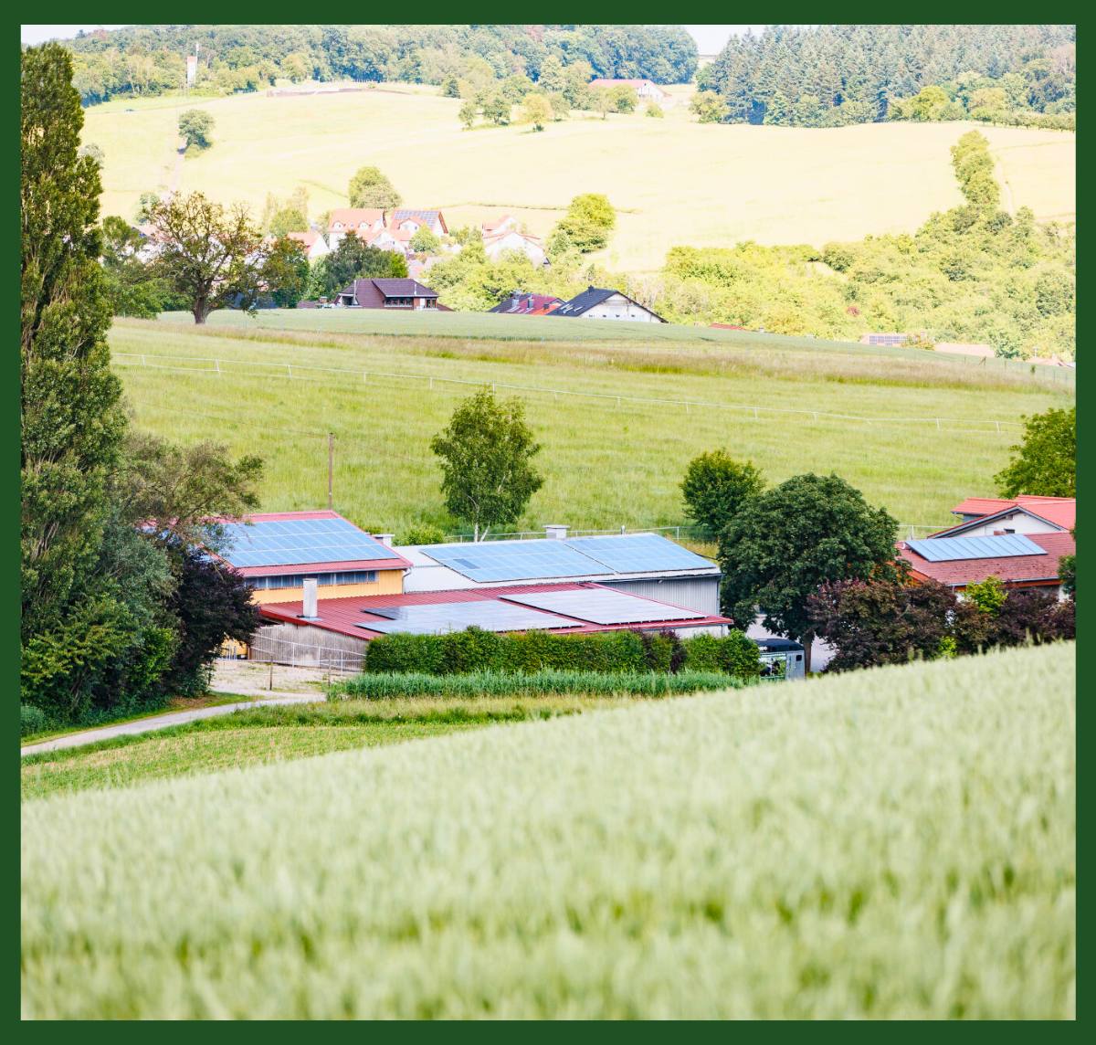 Blick auf das HBD-Unternehmensgelände, umgeben von Feldern und Hügeln in einer ländlichen Umgebung.